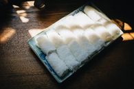 Close-up of a beautifully arranged bird's nest dessert on a tray, softly lit by natural light.
