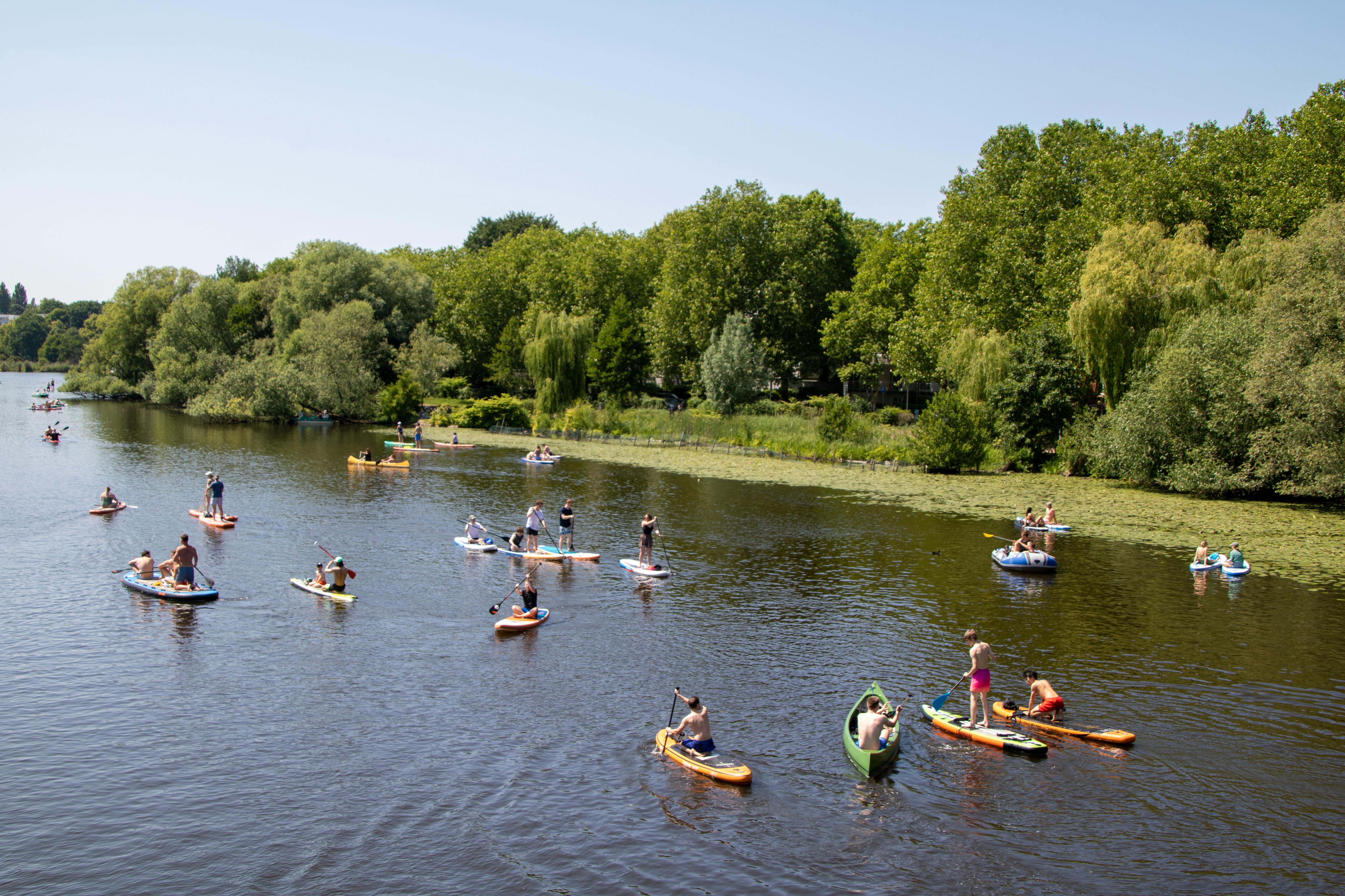 Enjoy a sunny day paddleboarding on the serene Alster River in Hamburg, Germany.