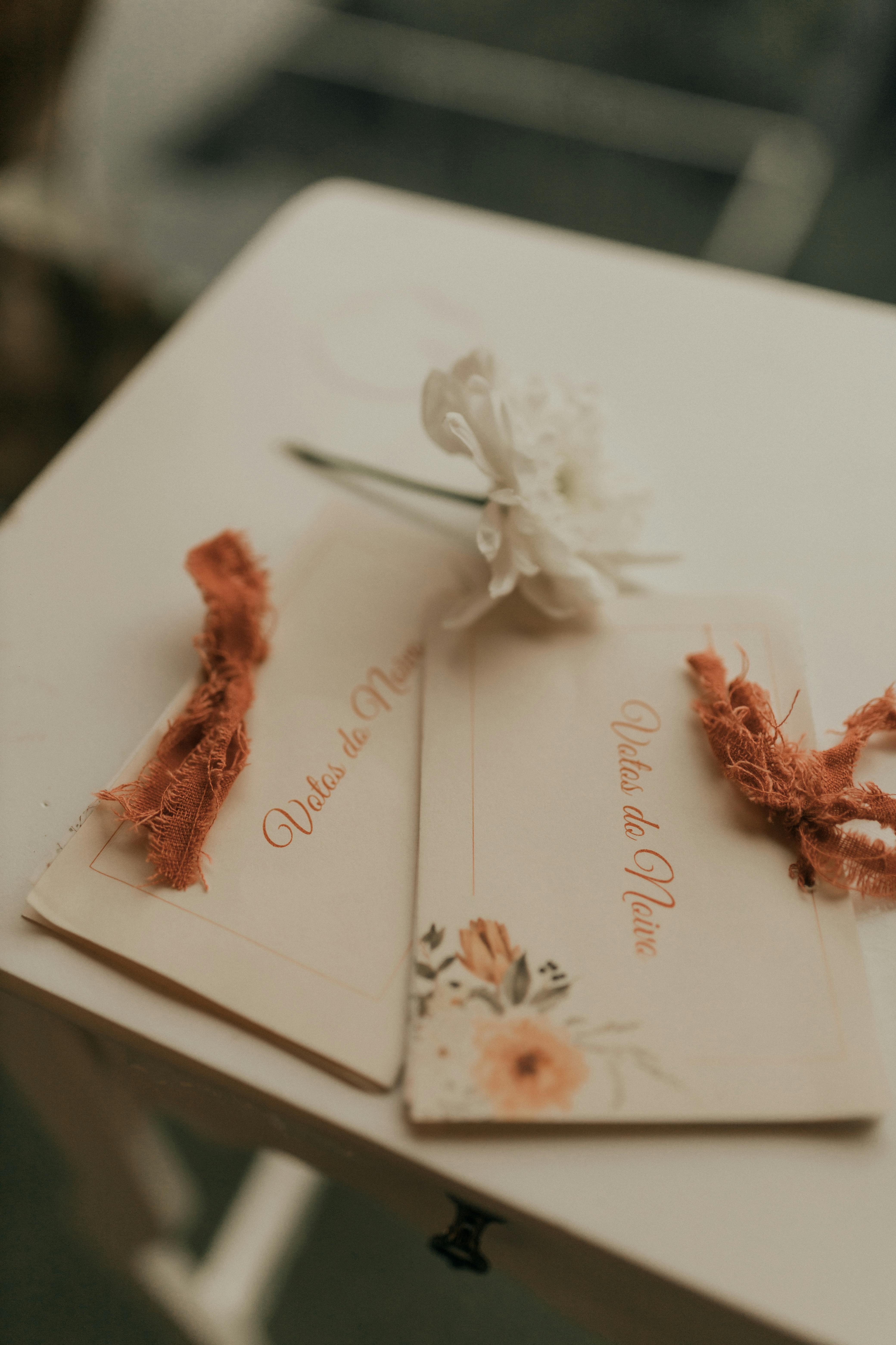 Gratuit Cărți de nuntă cu model floral pe o masă albă, perfecte pentru evenimente romantice. Fotografie de stoc