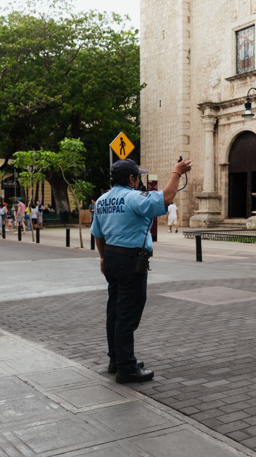 Free A municipal police officer directing traffic on a historic street during the day. Stock Photo