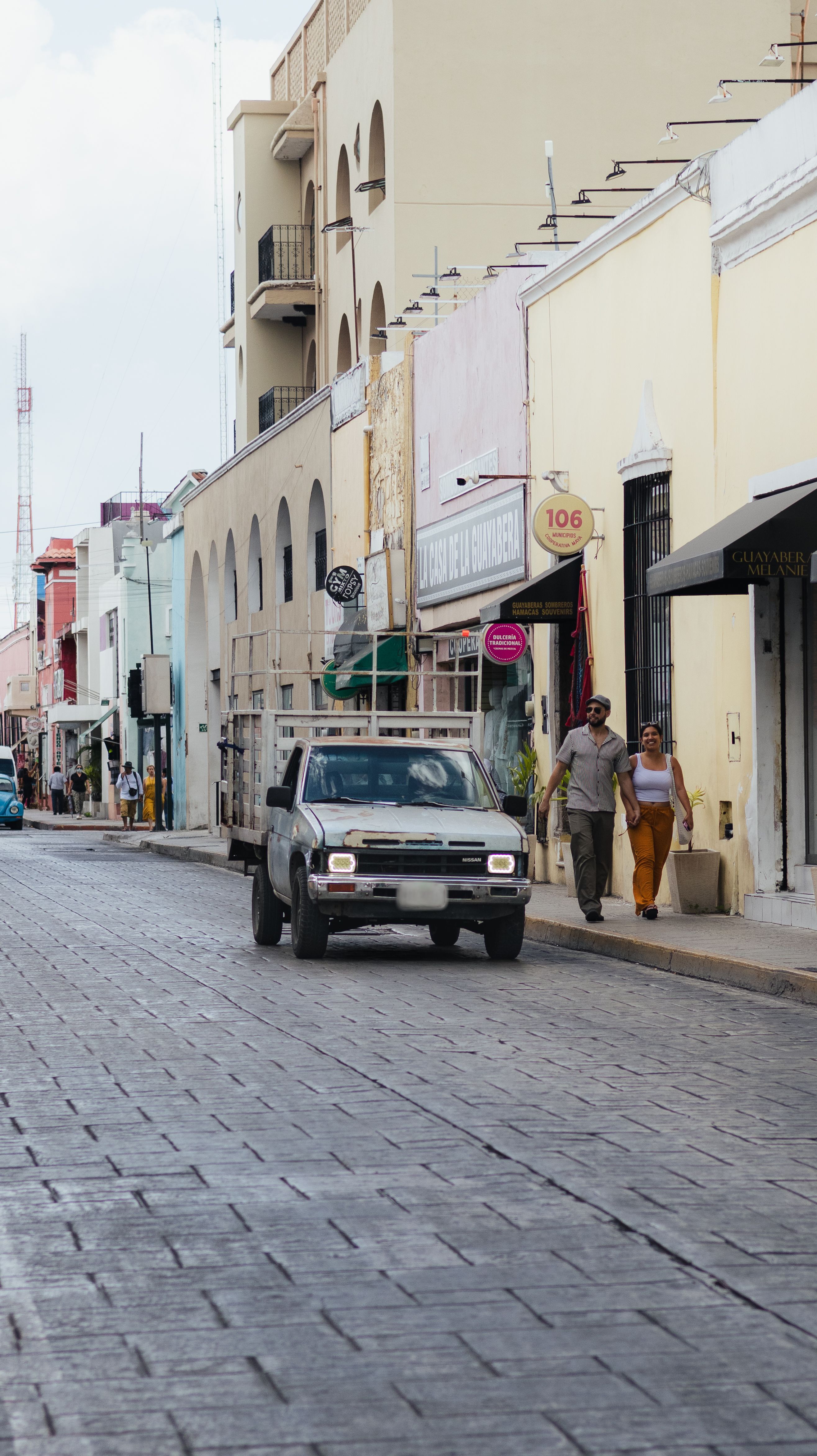 Busy street in a Yucatán city in Mexico with pedestrians and vehicles