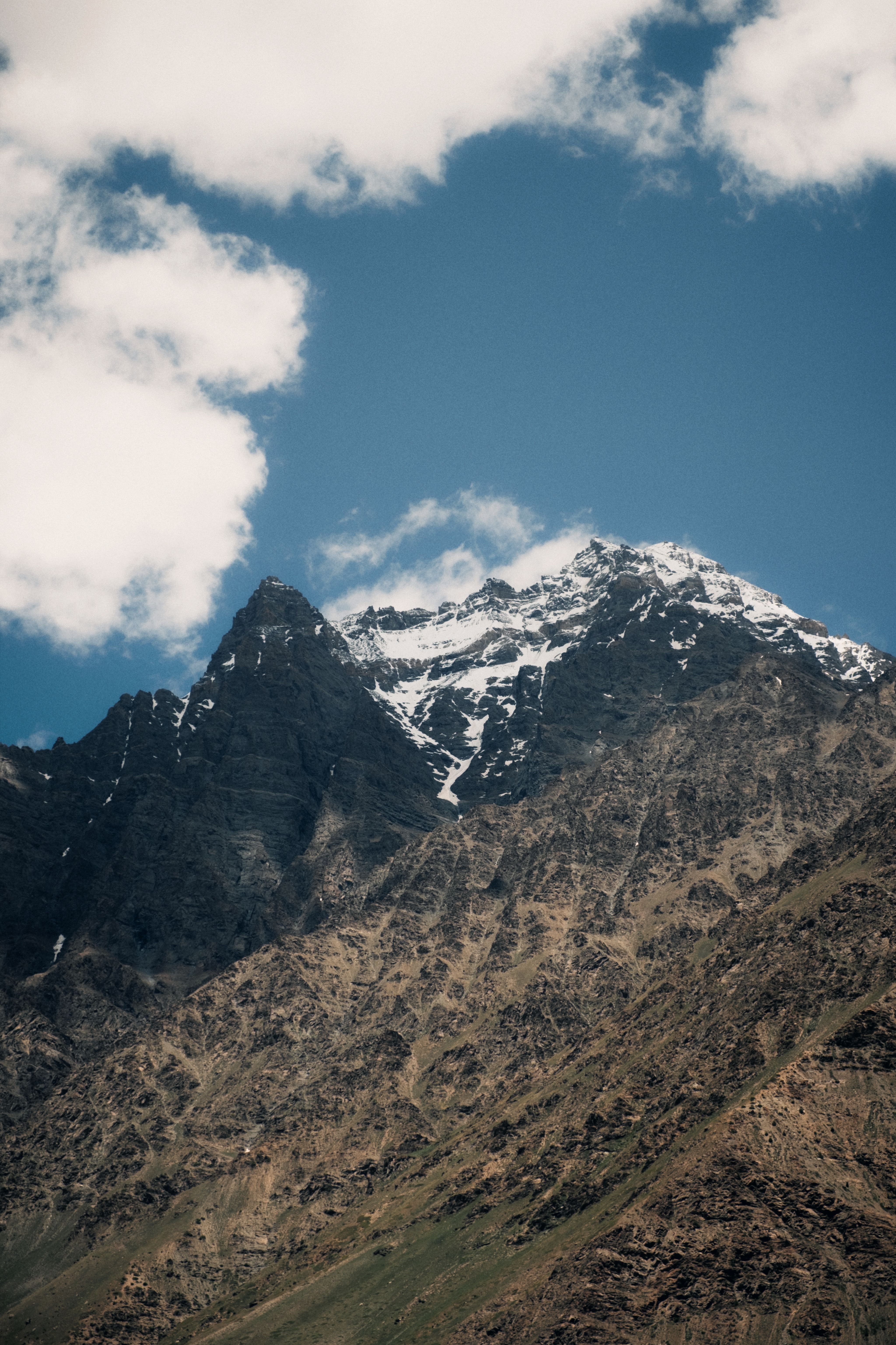 Breathtaking view of snow-capped Himalayan peaks in Lahul, Himachal Pradesh, India, under a clear blue sky.