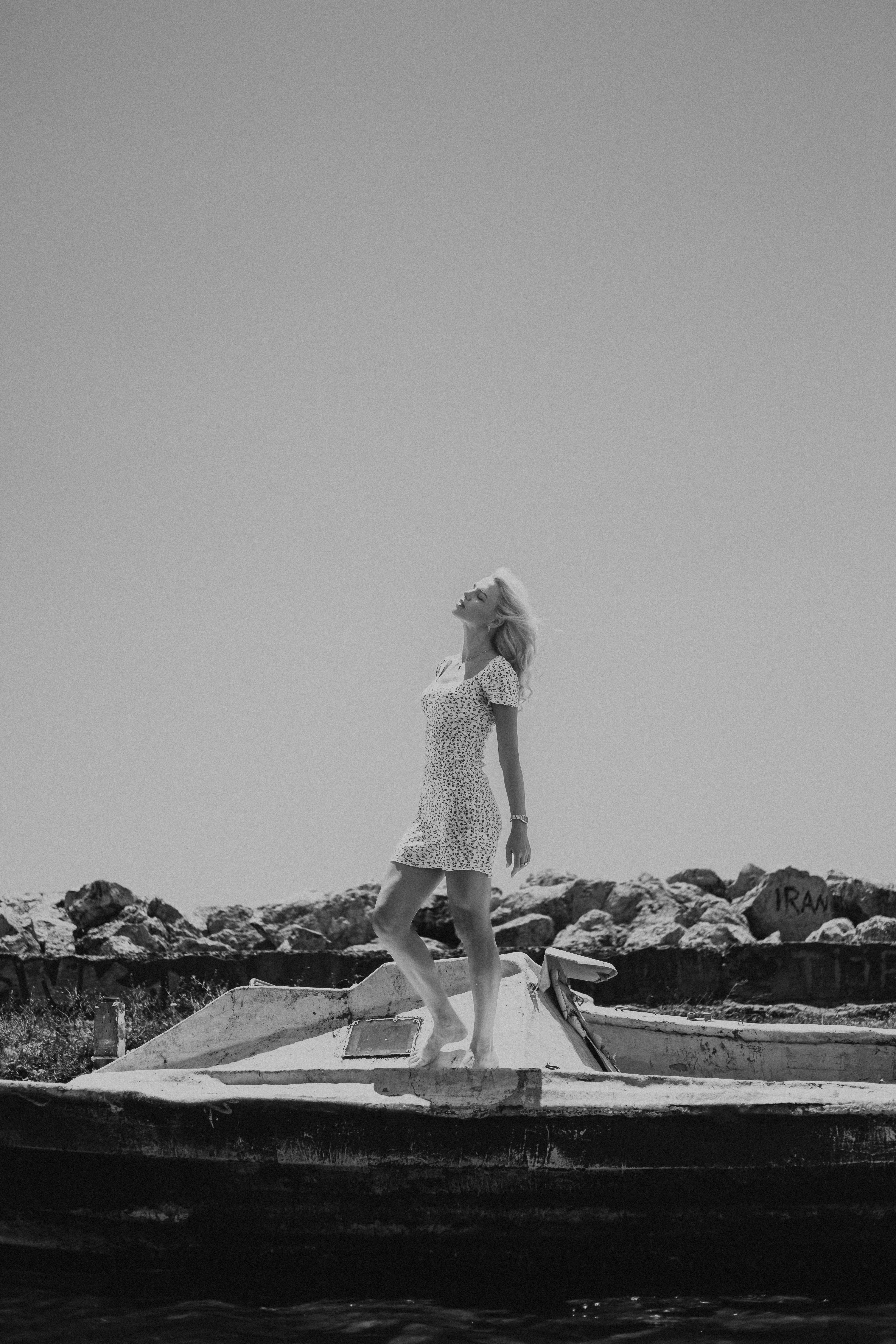 Black and white portrait of a woman standing gracefully on a rooftop outdoors.