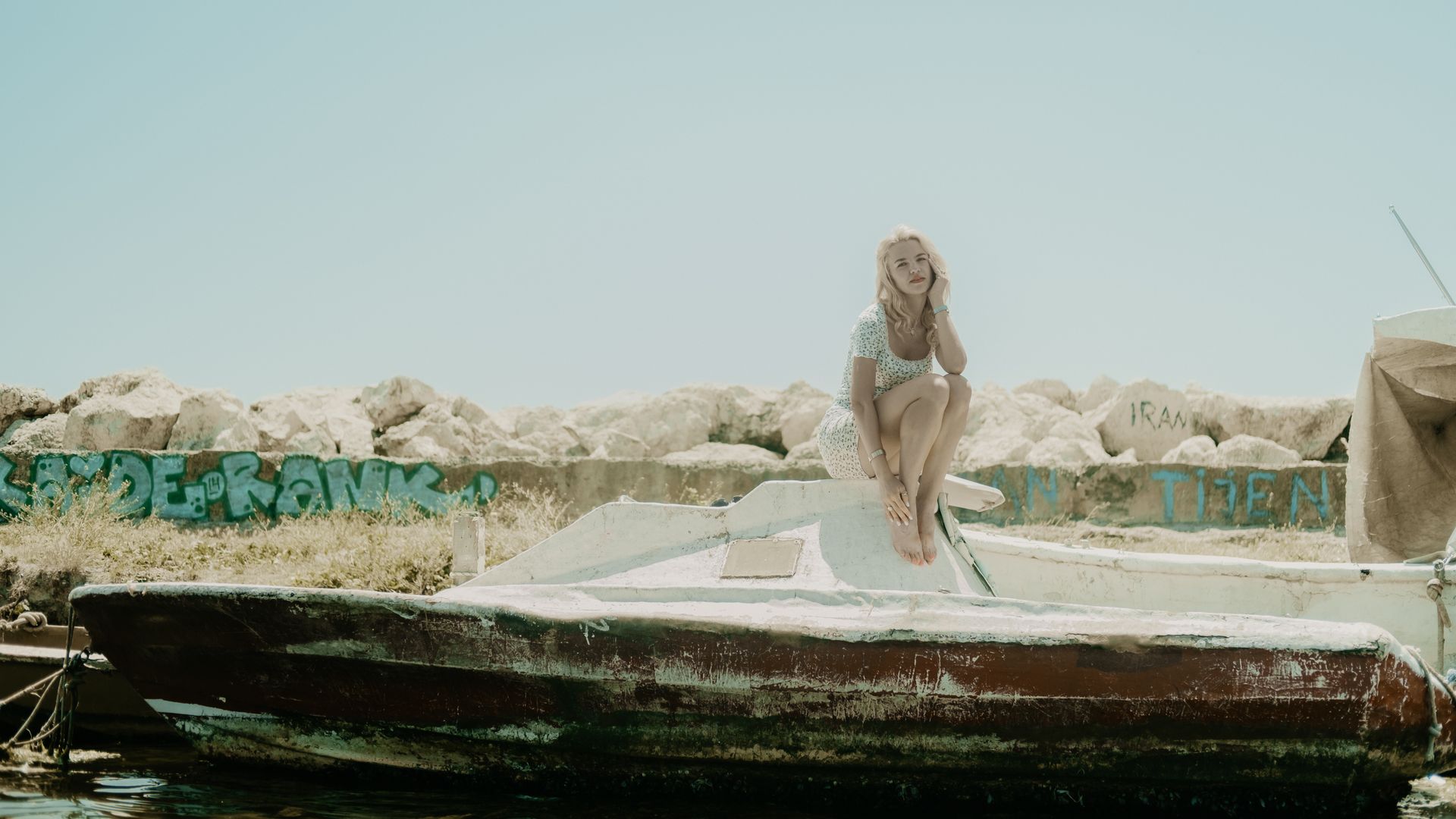 A woman poses elegantly on a boat at a harbor in Istanbul, Türkiye.