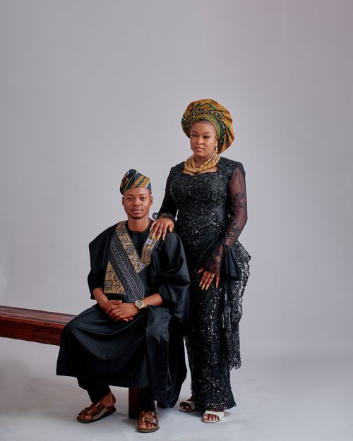 Free Elegant African couple in cultural attire posing against a neutral backdrop. Stock Photo