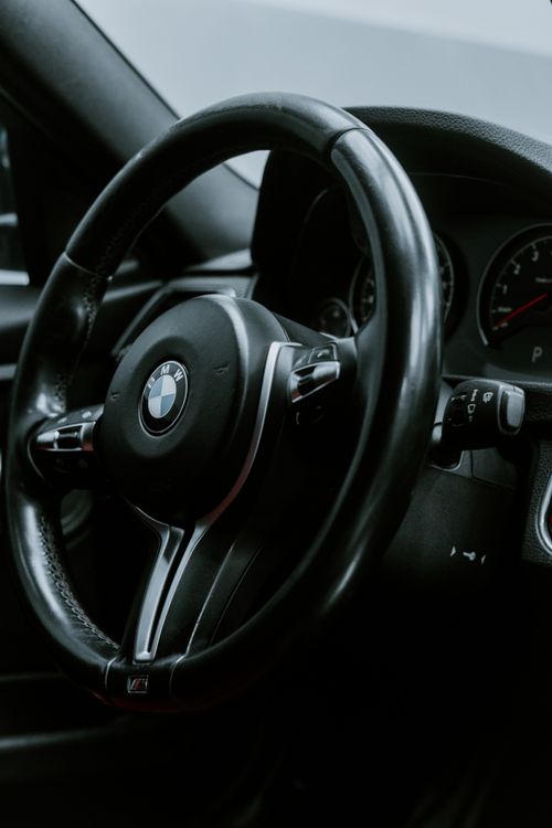 Free Close-up of a luxury car's steering wheel, showcasing modern design and premium feel. Stock Photo