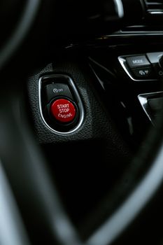 Detailed view of a start stop engine button in a car interior, highlighting modern automotive design.