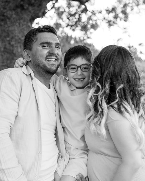 Free A cheerful family enjoying time together outdoors, captured in a black and white portrait. Stock Photo