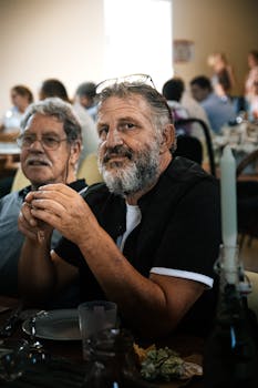Senior adults enjoying a communal meal with warm lighting and relaxed ambiance.
