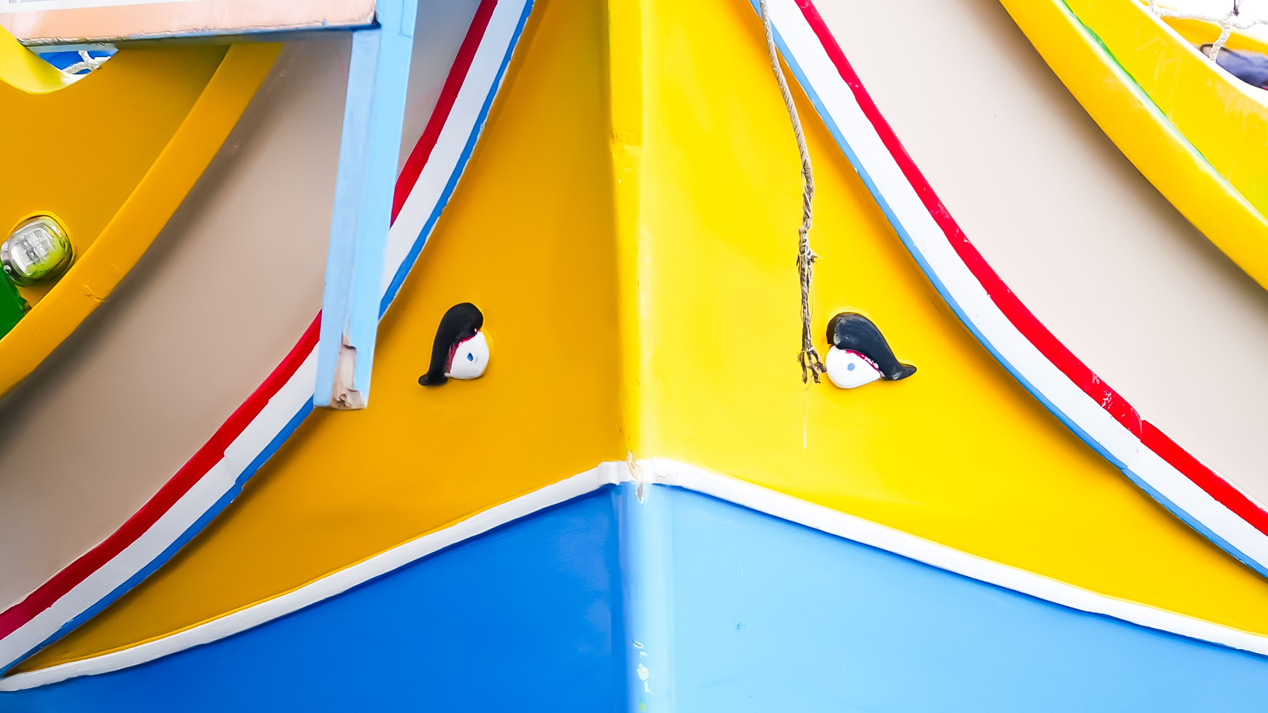 Close-up of a colorful Maltese luzzu boat featuring vibrant colors and traditional Eye of Osiris artwork.