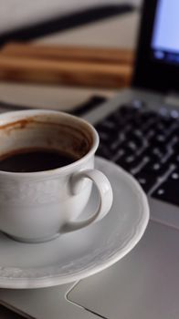 Close-up of a coffee cup on a laptop, ideal for productivity or remote work concepts.