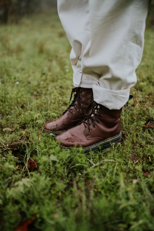 Free A close-up shot of brown leather boots standing on a grassy surface, perfect for exploring nature. Stock Photo