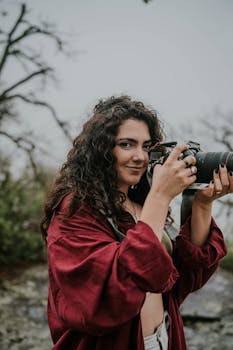 Portrait of a woman taking photos in a natural setting, showcasing her passion for photography.