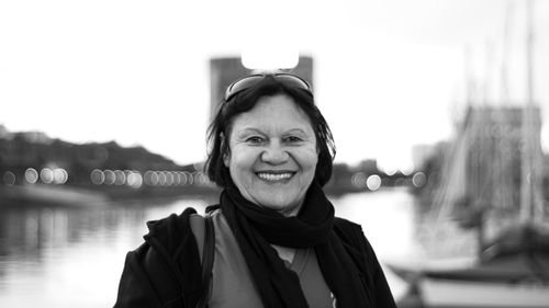 Free Captivating black and white portrait of a smiling woman by Buenos Aires waterfront. Stock Photo