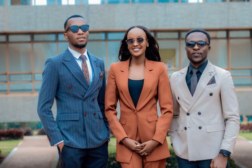 Free Three young professionals in stylish suits posing confidently outdoors. Stock Photo