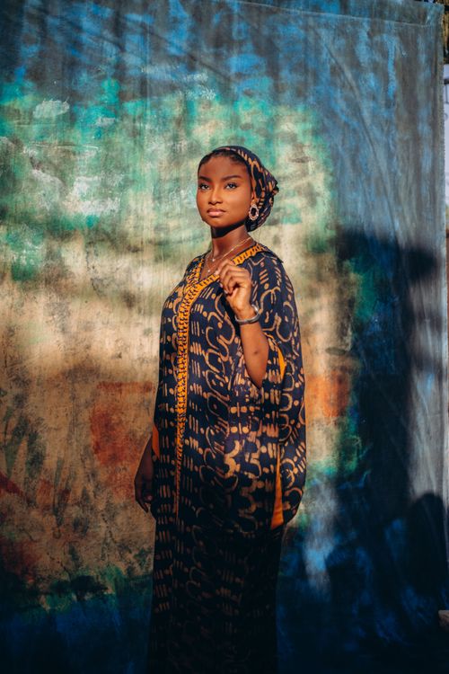Free Portrait of a woman in traditional African dress with a colorful backdrop. Stock Photo