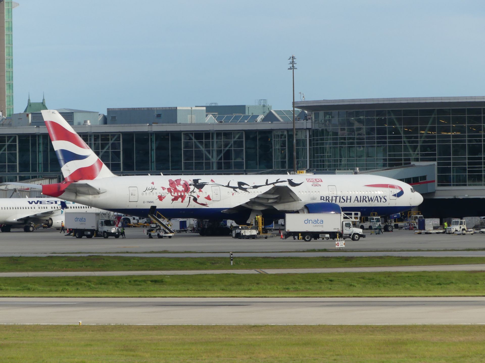 British Airways airplane on a runway at an international airport terminal ready for boarding.
