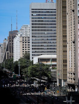 Dynamic city view with tall skyscrapers, lush greenery, and bustling streets below.