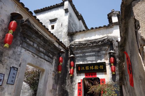 Free Ancient Chinese building adorned with red lanterns and decorative calligraphy signs, capturing cultural heritage. Stock Photo