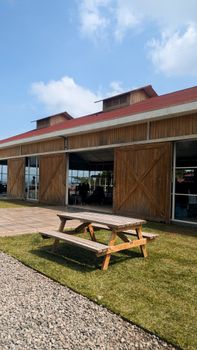 A wooden barn with a picnic table outside under a clear blue sky.