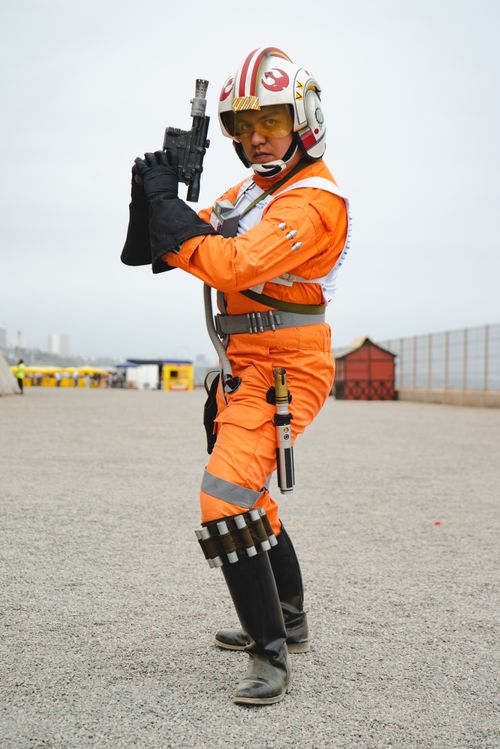 Free A cosplayer dressed as a space pilot holding a blaster gun outdoors. Stock Photo