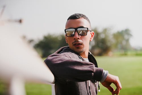 Hombre De Chaqueta Negra Con Gafas De Sol Apoyado En Rieles Blancos