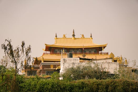 A serene view of a Buddhist temple in Varanasi with its distinctive golden roof framed by trees.