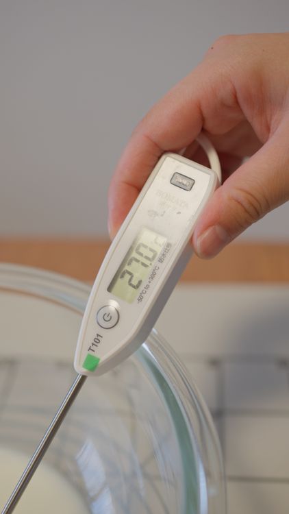 Home cook checking milk temperature with a digital thermometer