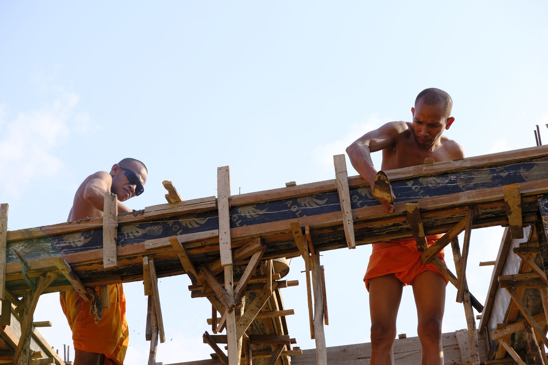 Monks involved in construction activities, showcasing traditional Buddhist practices in Cambodia.
