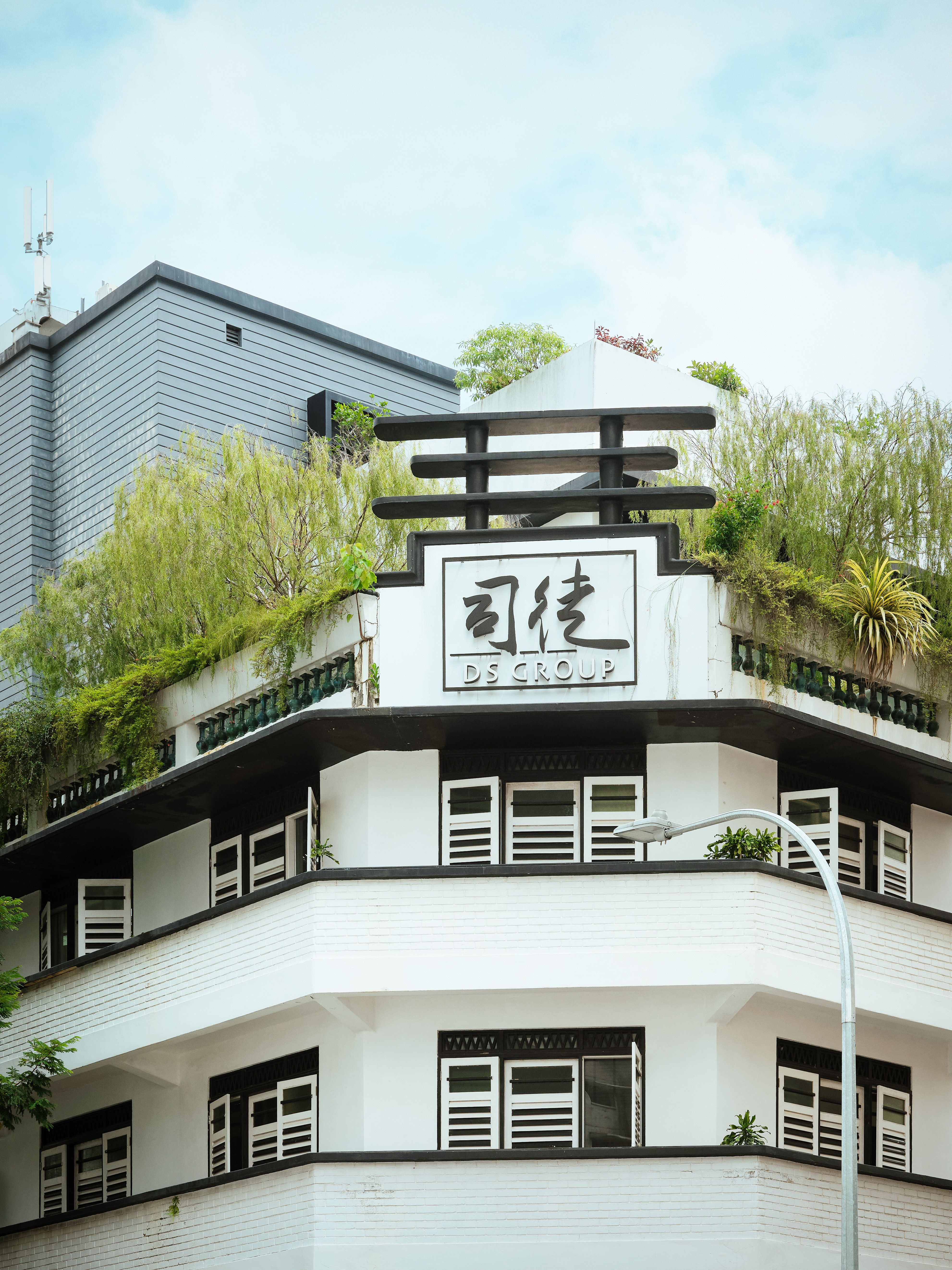 City building with rooftop garden, contemporary Asian architecture, DS Group sign.