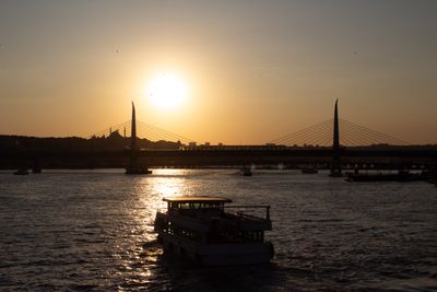 Ferry silhouetted against a river sunset — photo by Fatih Altuntaş on Pexels