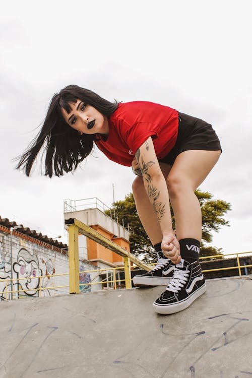 Woman In Red T-Shirt, Black Short-Shorts, And Black Vans Sk8-Hi Sneakers ·  Free Stock Photo