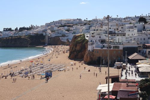 Free Charming beachfront scene with cascading white-washed buildings and golden sands in Albufeira, Portugal. Stock Photo