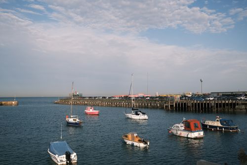 Free Peaceful harbor scene with boats moored under a picturesque sky. Stock Photo