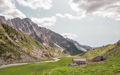 Campo De Hierba Verde Cerca De La Montaña Bajo El Cielo Nublado