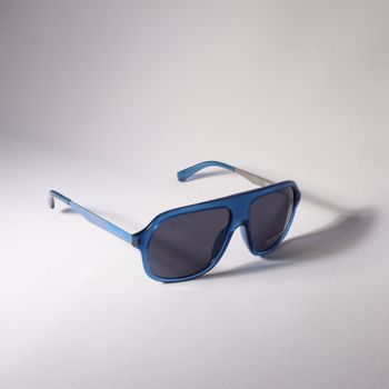 Modern blue aviator sunglasses with a sleek design, captured against a neutral white backdrop.