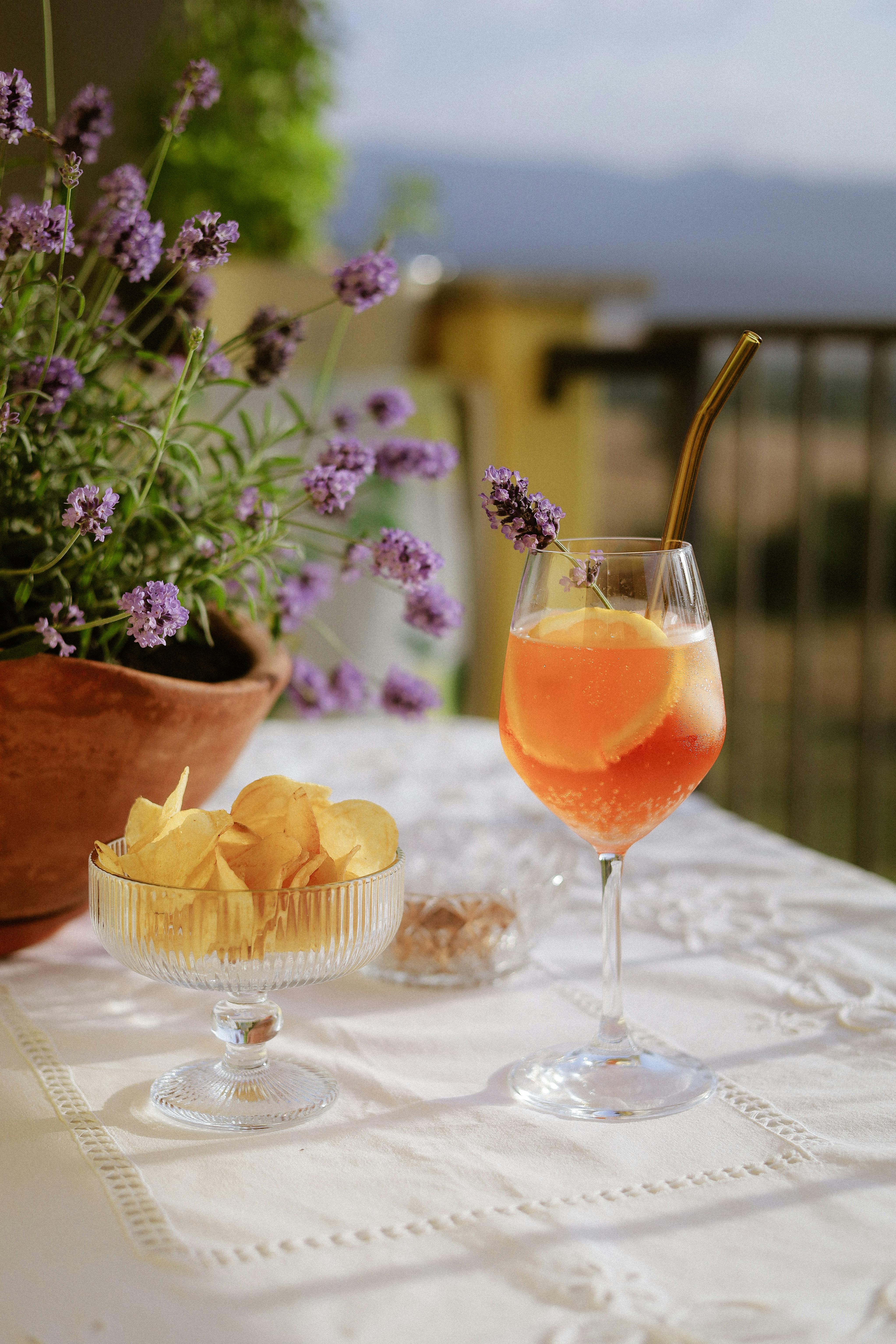 Aperol Spritz arancione servito con patatine su tavolo all'aperto