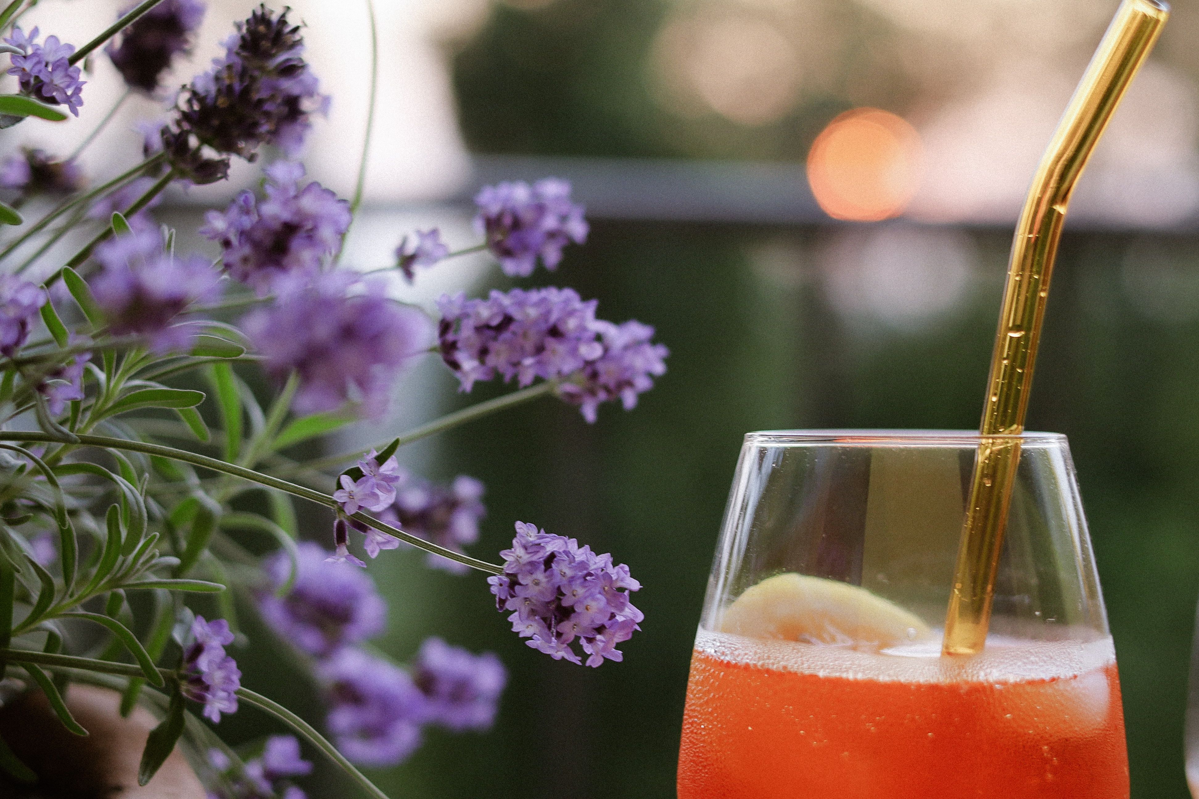 Glass of lavender orangeade with ice and orange zest