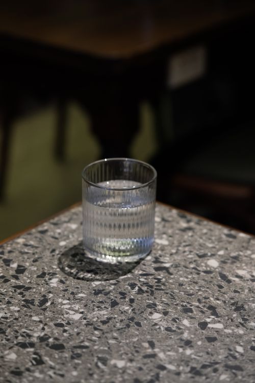 Free A clear glass of water on a stylish terrazzo tabletop indoors, showcasing modern design. Stock Photo