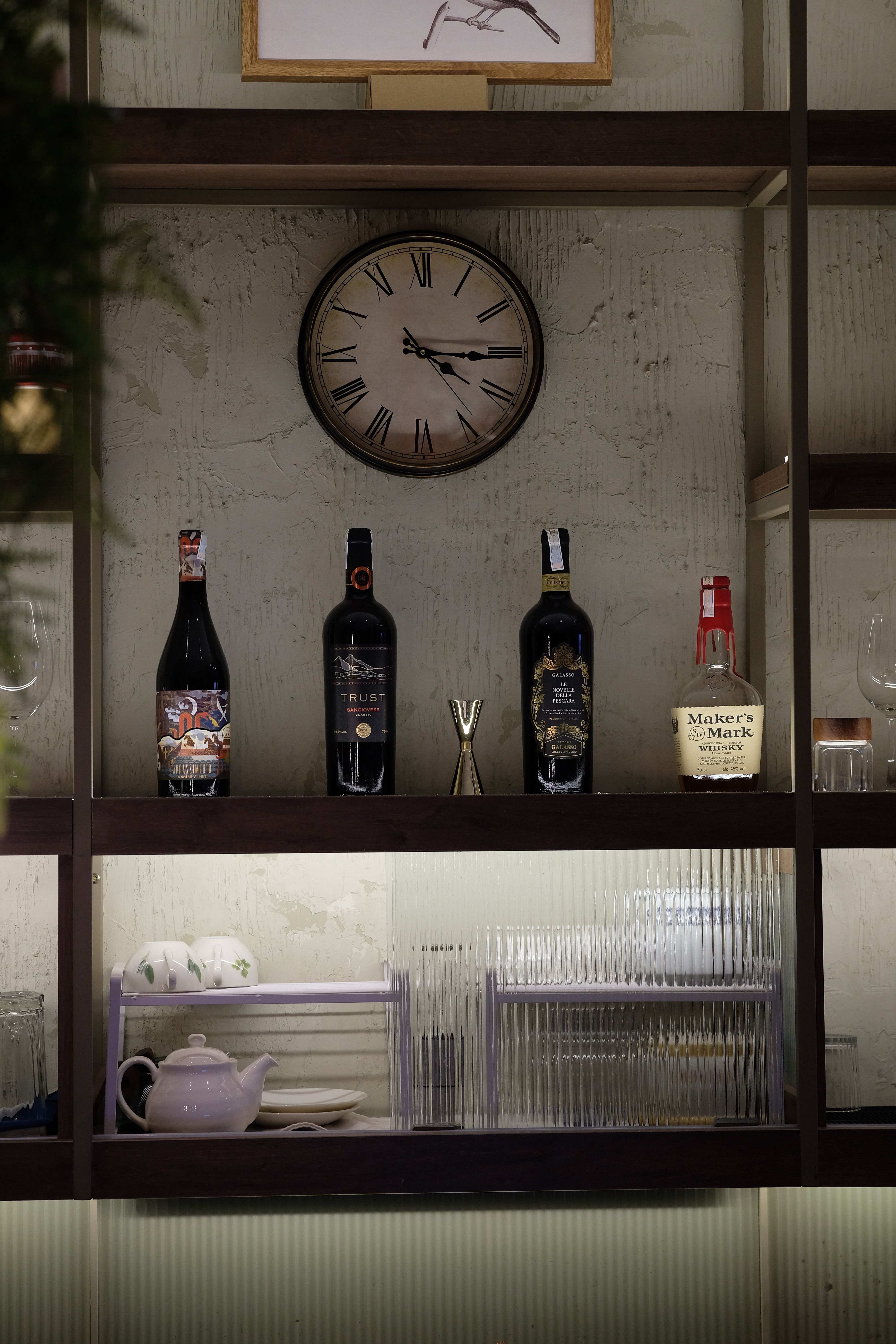 Brass-framed wall clock mounted next to a coffee bar hutch