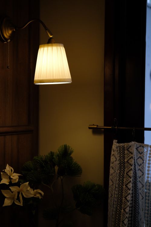 Free Warmly lit interior with a wall lamp and decorative elements. Stock Photo