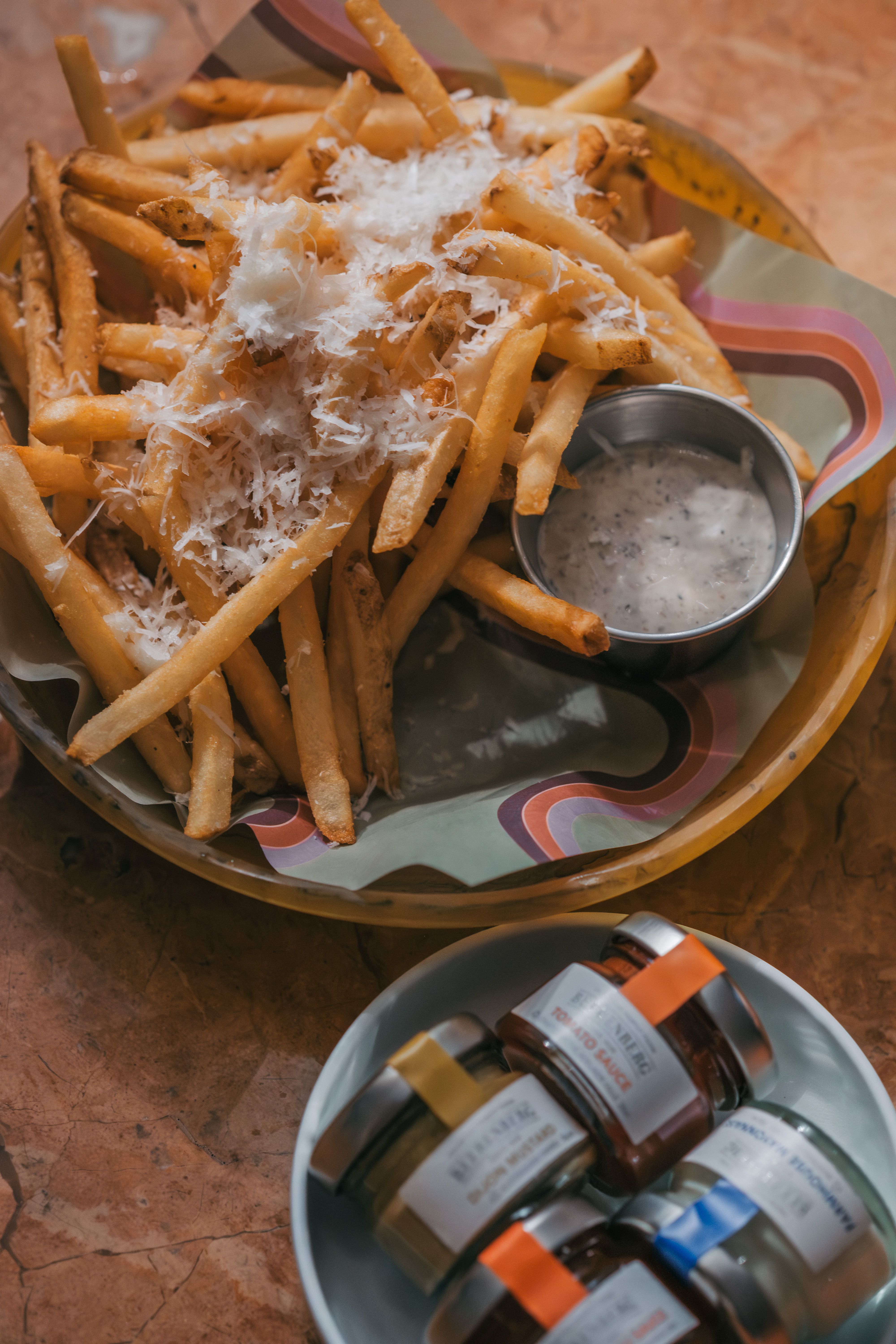 Appetizing parmesan truffle fries served with various jams and dips, perfect for food lovers.
