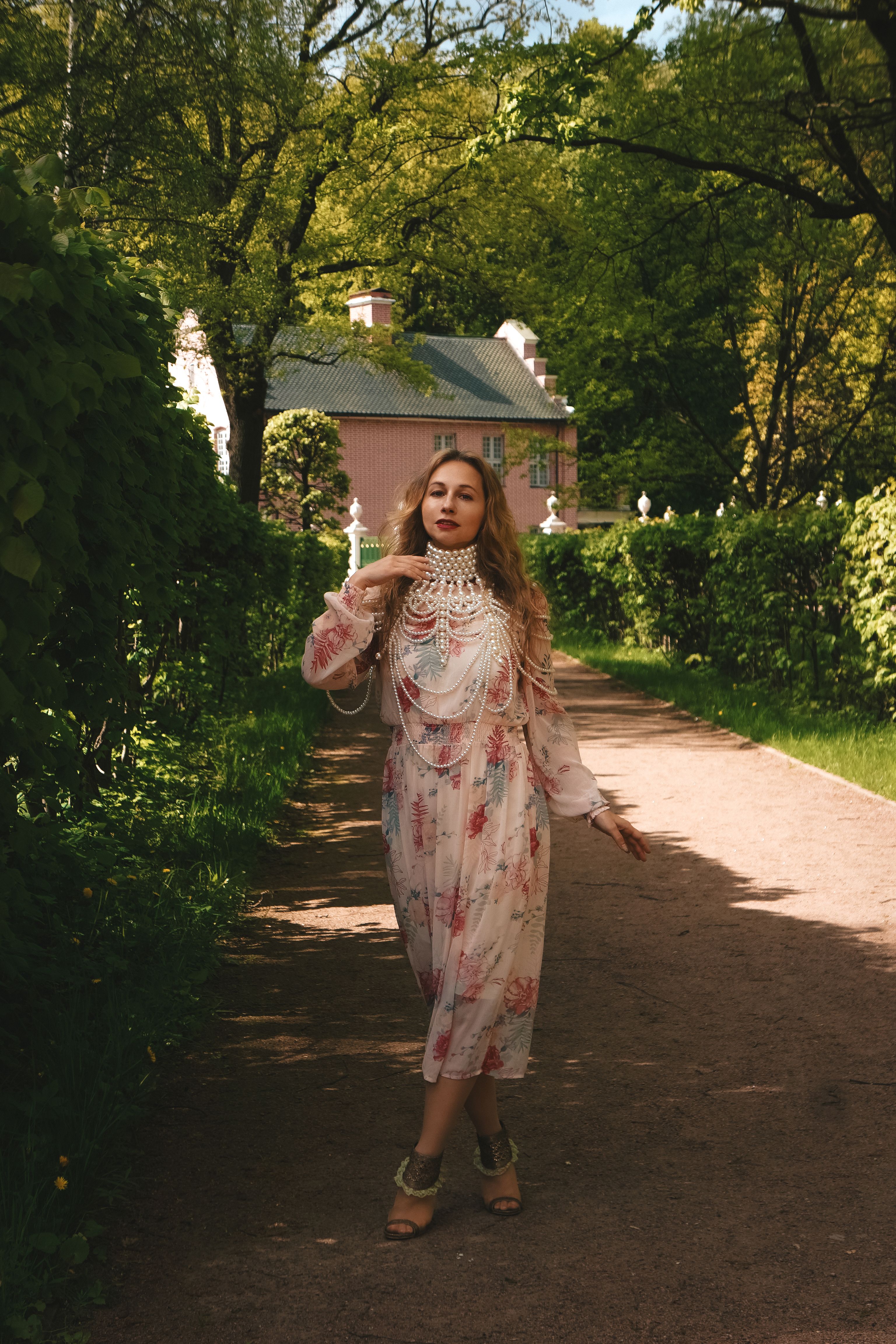 Elegant Woman Walking in a Garden Pathway