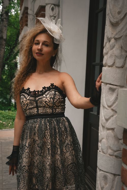 Free Portrait of a woman in a lace dress outdoors, exuding elegance and charm. Stock Photo