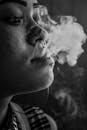 艺术单色肖像捕捉了从女人唇边卷曲升起的烟雾