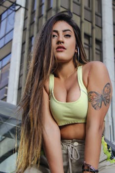 一位时尚女性自信地在户外摆出蝴蝶纹身的姿势