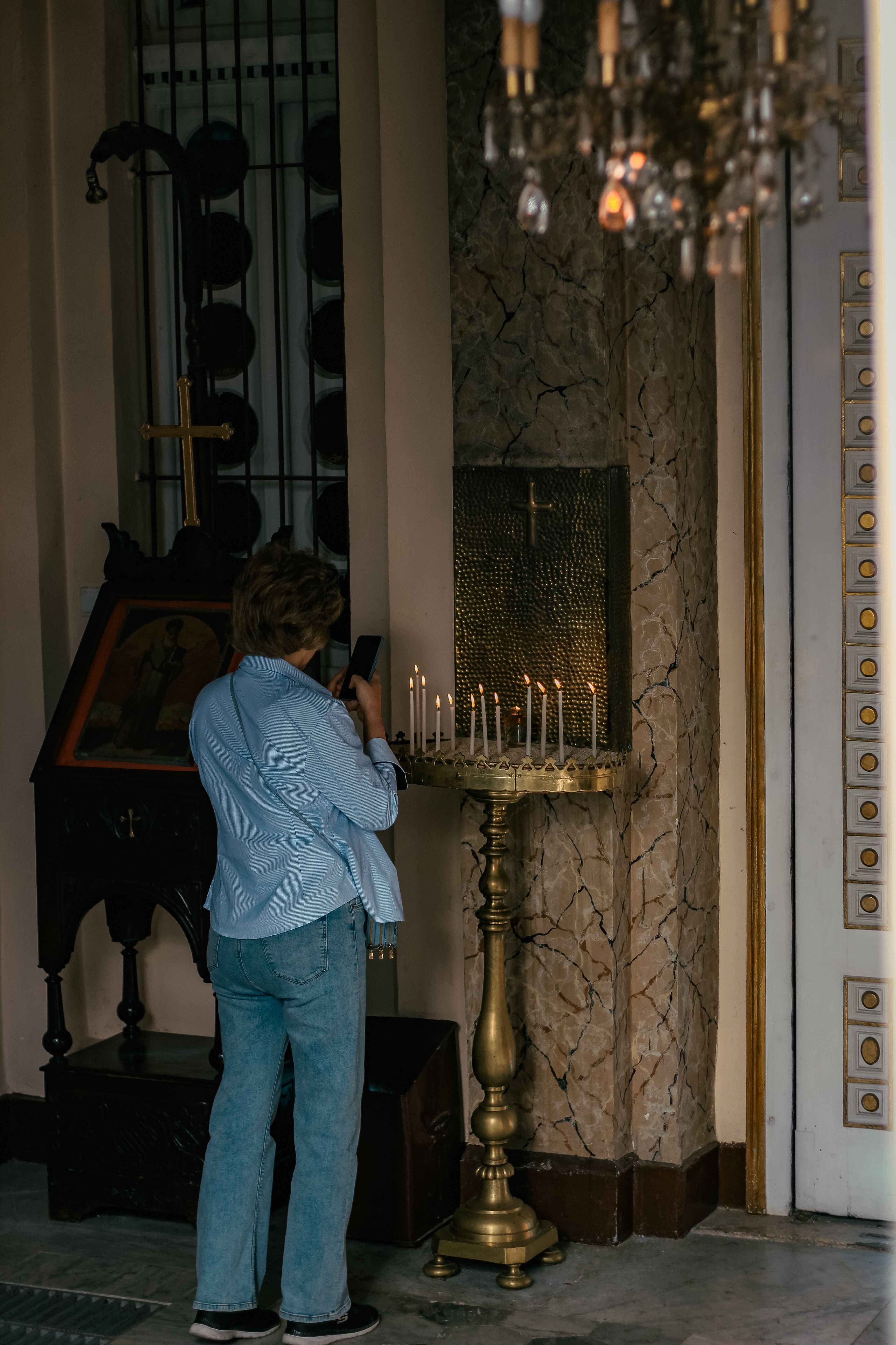 Person Lighting Candles in a Church Interior · Free Stock Photo