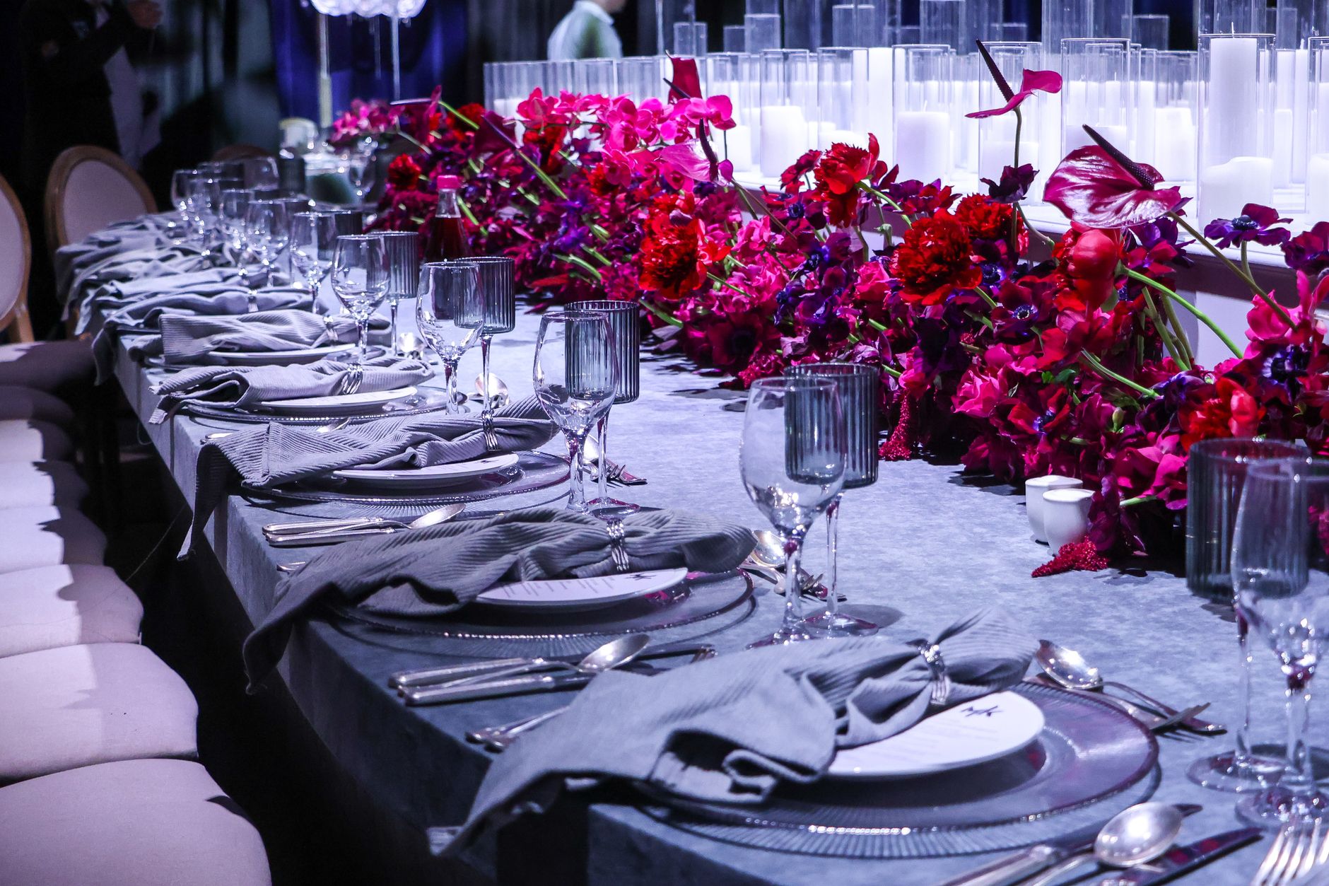 A beautifully set wedding reception table adorned with vibrant floral arrangements and chic tableware.