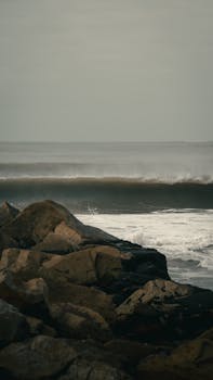 Moody seascape with crashing waves on rocky shoreline in Mar del Plata, Argentina.