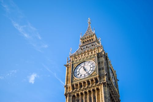 Free Low Angle View of Clock Tower Against Blue Sky Stock Photo